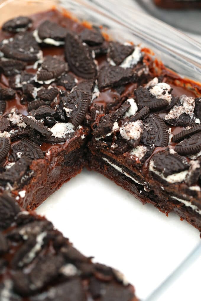 sliced oreo stuffed brownies in a baking dish, topped with chopped oreos