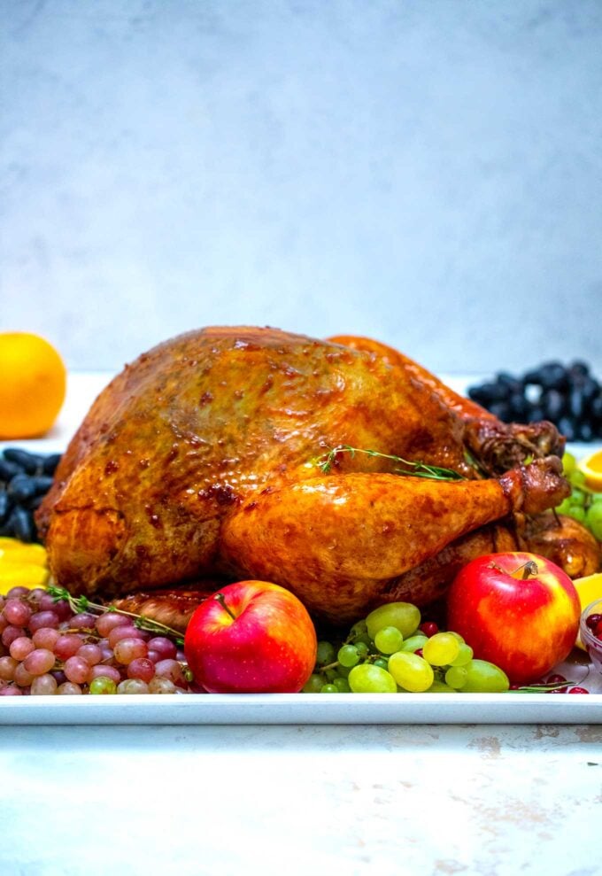 crispy and browned oven roasted turkey on a plate with apples and grapes