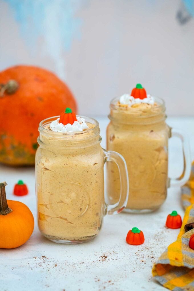 Light pumpkin mousse served in jars on a table 