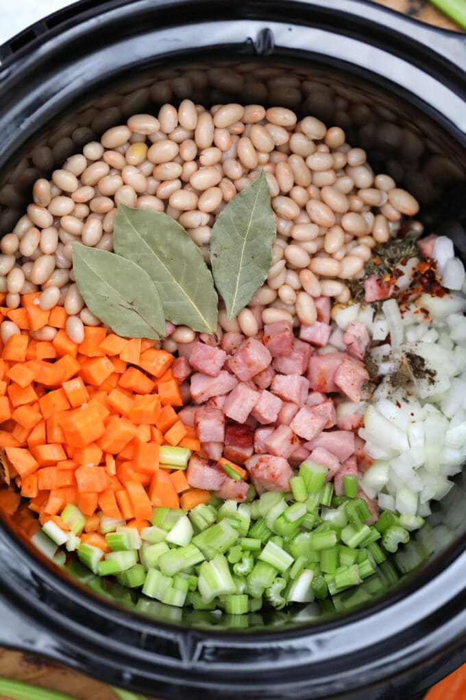 Slow Cooker Ham and Bean Soup smells divine as it simmers and it tastes just as amazing! #slowcooker #crockpotrecipes #hamandbeansoup #souprecipes #sweetandsavorymeals