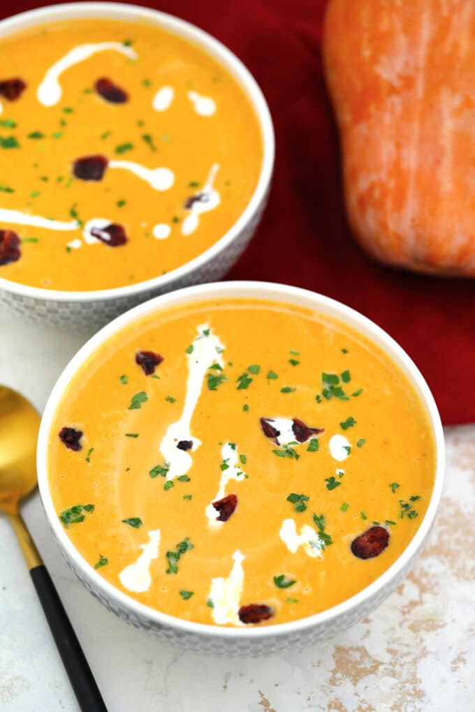 Roasted butternut squash soup in a bowl topped with chopped parsley