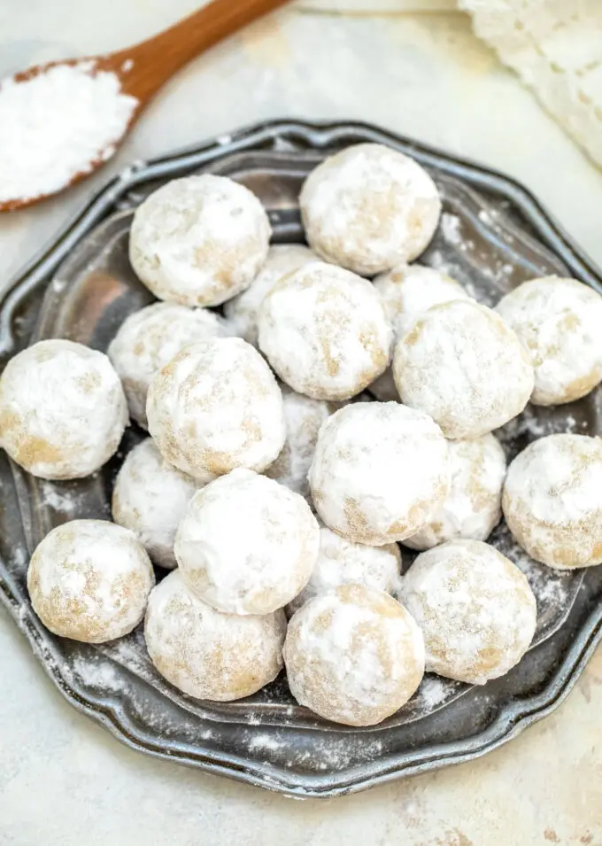 image of mexican wedding cookies topped with powdered sugar on a silver plate