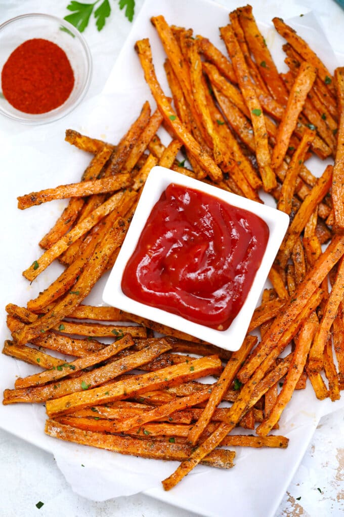 Oven roasted sweet potato fries on a white plate and ketchup.