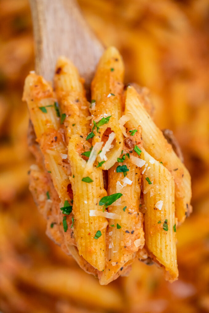 Penne alla vodka pasta on a wooden spoon