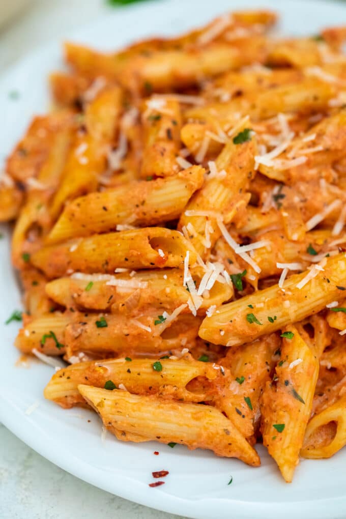 Penne alla vodka garnished with shredded parmesan cheese photo.