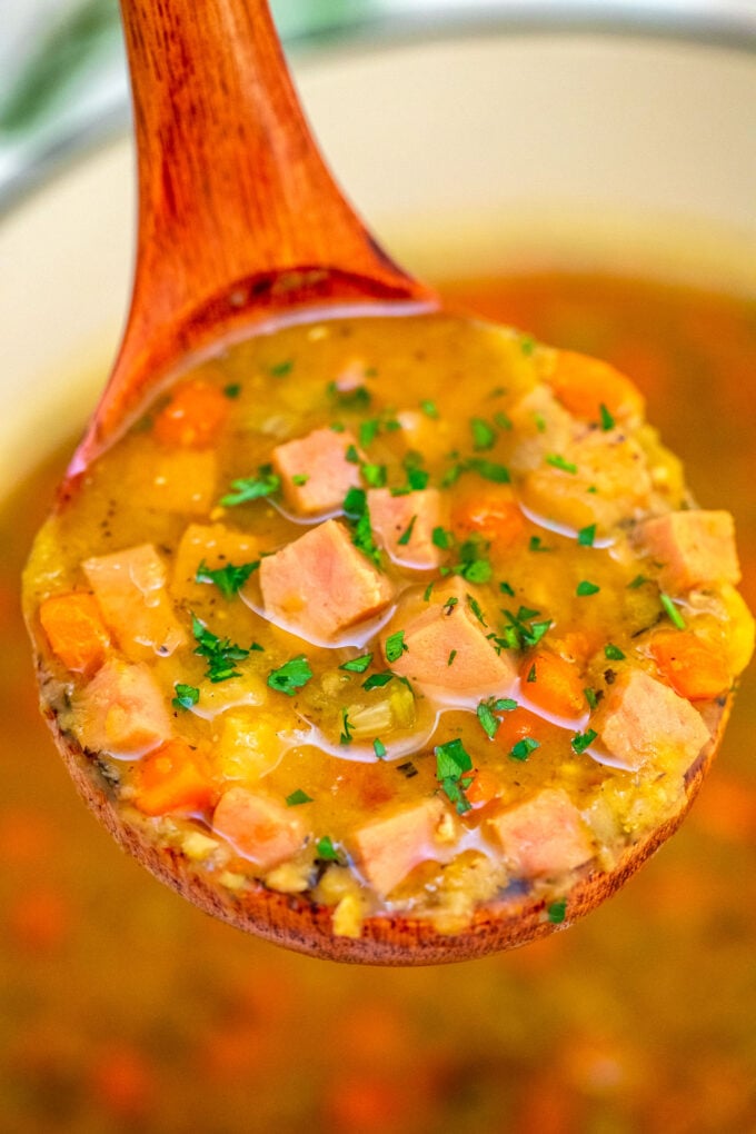 image of ham spit soup garnished with chopped parsley on a wooden spoon
