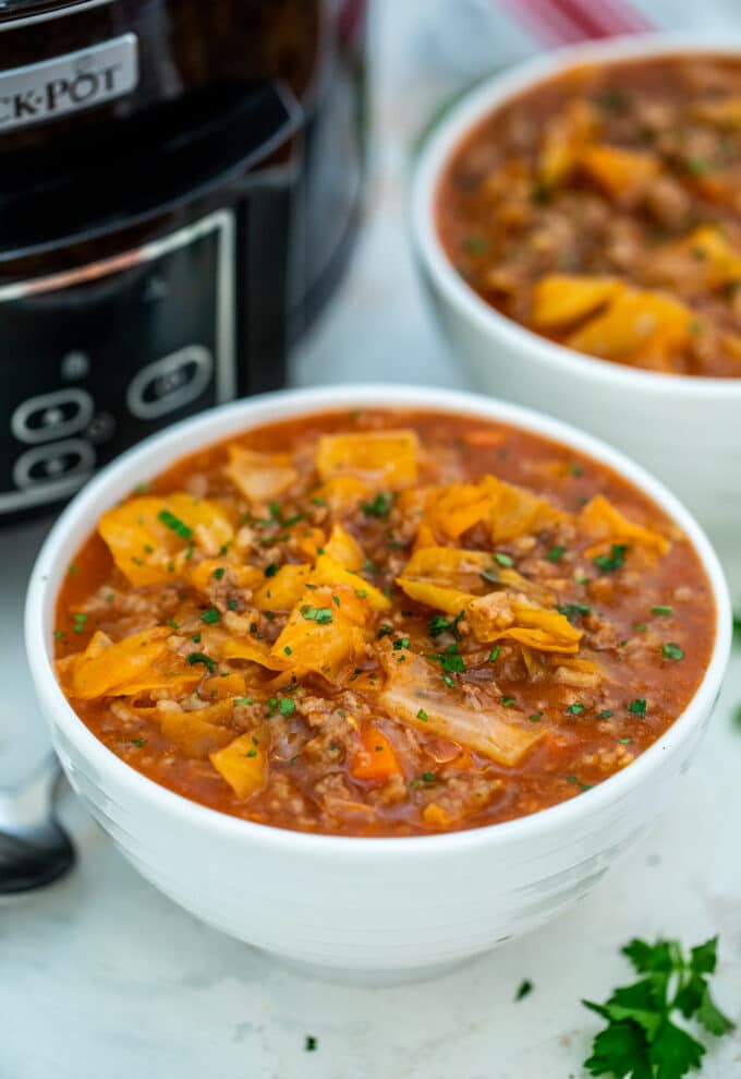 A bowl of homemade cabbage roll soup garnished with chopped parsley