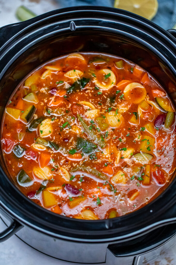 ¡La sopa Minestrone vegetariana de cocción lenta podría ser su salvavidas de cena de noche ocupada entre semana! Es saludable, abundante y la manera perfecta de usar las verduras sobrantes. #slowcooker # crockpotrecipes # souprecipes # ministrone # sweetandsavorymeals