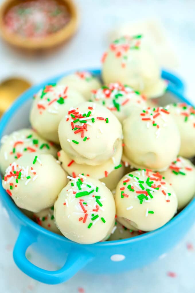 Sugar Cookie Truffles are made with cake mix and coated in delicious white chocolate, topped with Christmas sprinkles. #nobakedesserts #sugarcookies #christmasrecipes #christmasdesserts #sweetandsavorymeals