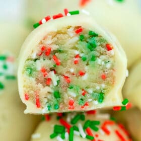 Sugar Cookie Truffles are made with cake mix and coated in delicious white chocolate, topped with Christmas sprinkles. #nobakedesserts #sugarcookies #christmasrecipes #christmasdesserts #sweetandsavorymeals