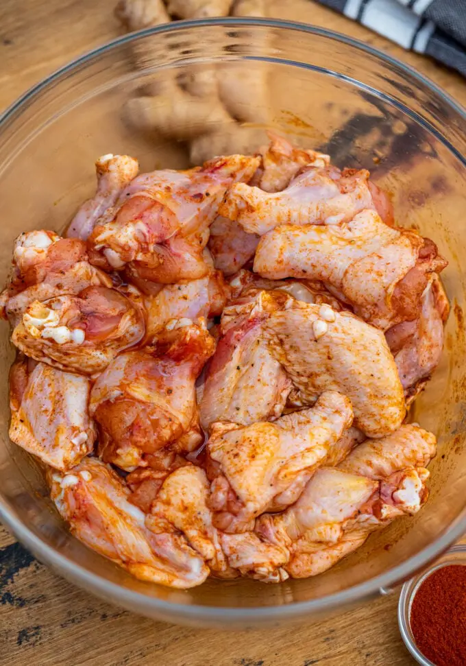 seasoned raw chicken wings in a large bowl
