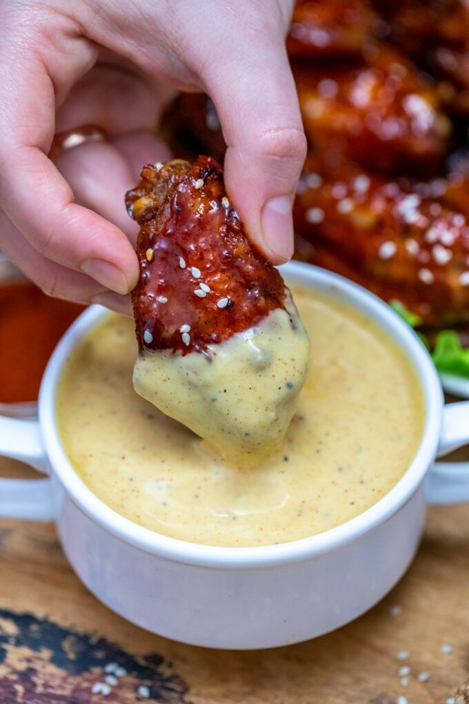 dipping a honey garlic chicken wings dipped in honey mustard sauce