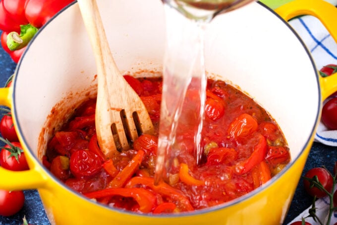Adding water to make tomato and red bell pepper soup.