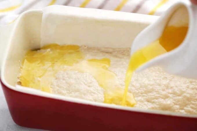 pouring melted butter on top of beer bread batter in a loaf pan