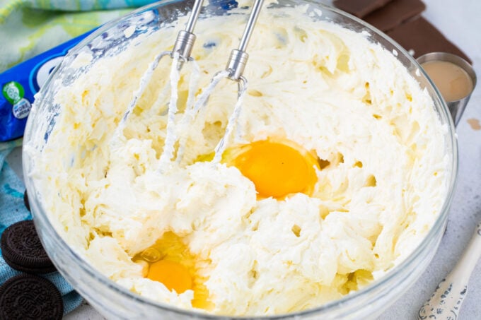 Whipping eggs into cream cheese mixture.