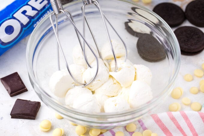 Beating cream cheese in a bowl.