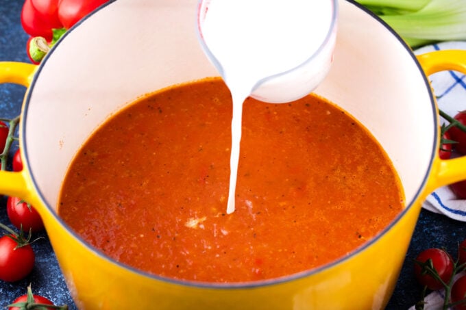 Adding cream to make tomato bisque.