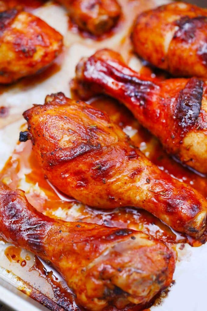 Crispy baked chicken legs with honey and seasoning on a baking sheet