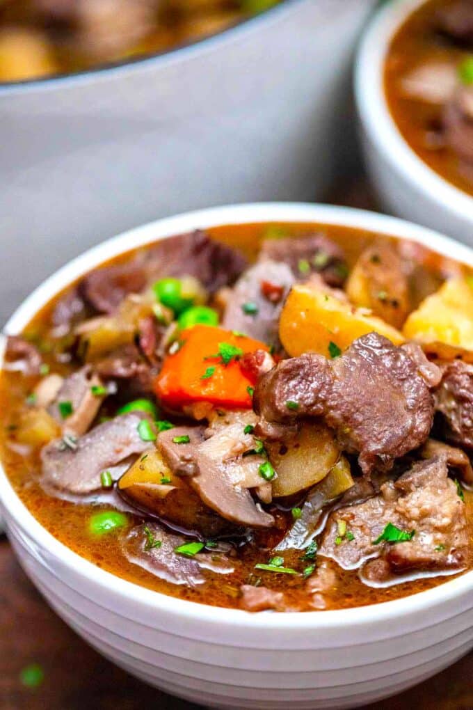 Close shot of a bowl of hearty lamb stew with potatoes and carrots.
