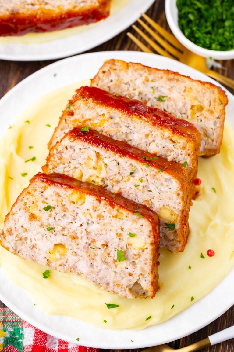 Sliced cheesy turkey meatloaf with Pepper Jack cheese over mashed potatoes.