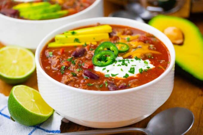 a bowl of homemade crockpot Wendy's chili topped with cheese, japaleno slices and sour cream