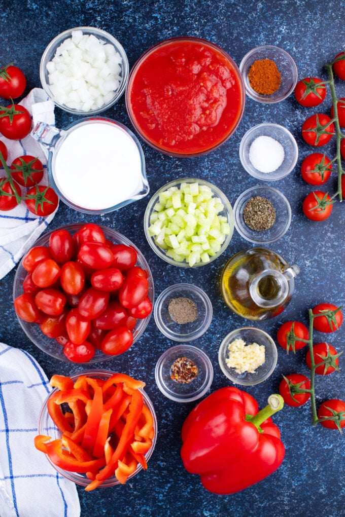Overhead shot of tomato bisque ingredients in bowls on a table.