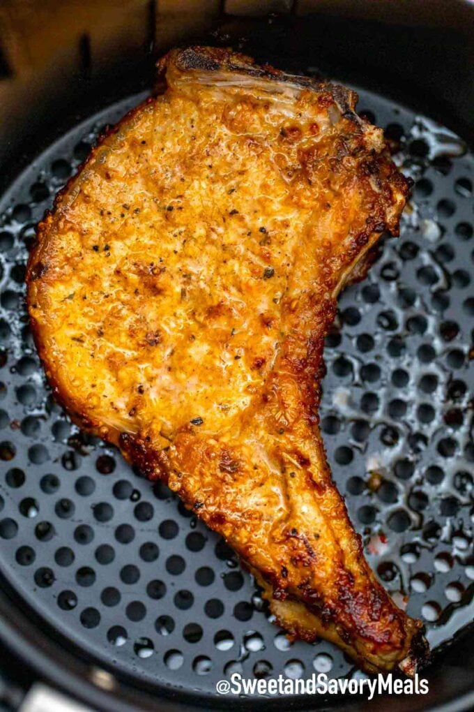 crispy pork chop cooking in the air fryer basket