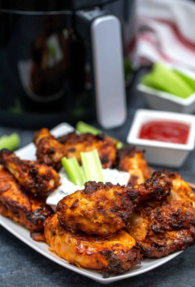 Healthy fried chicken with celery and tzatziki sauce on a white plate