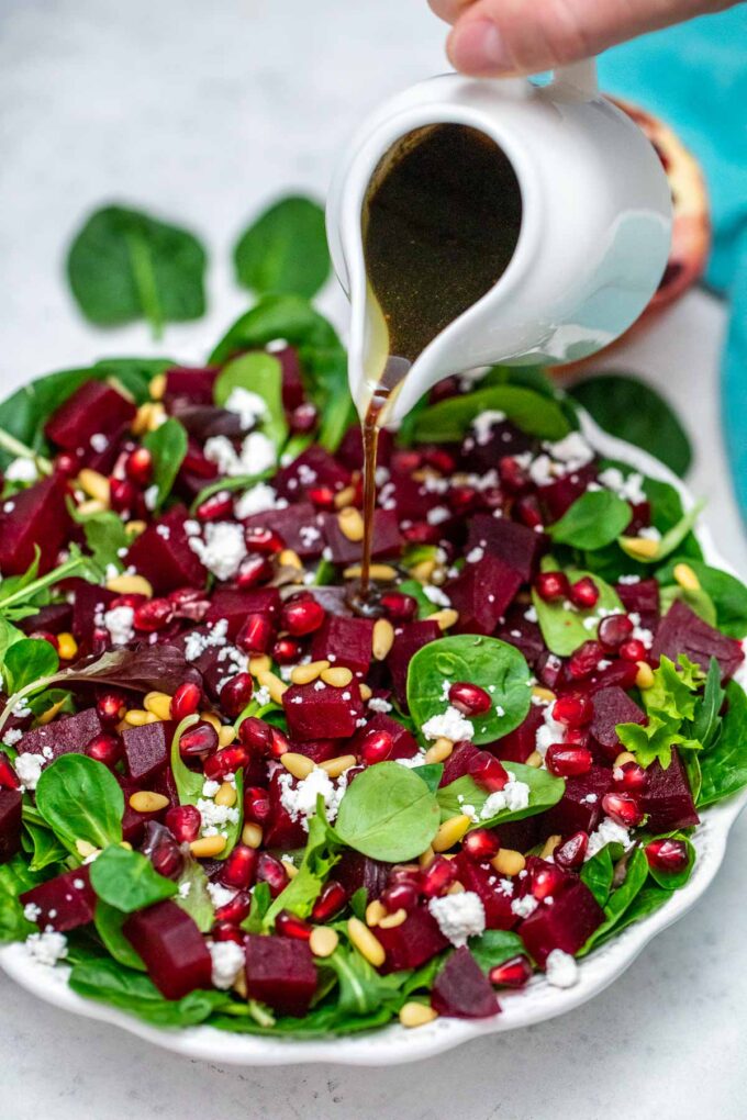 image of salad dressing being poured on salad