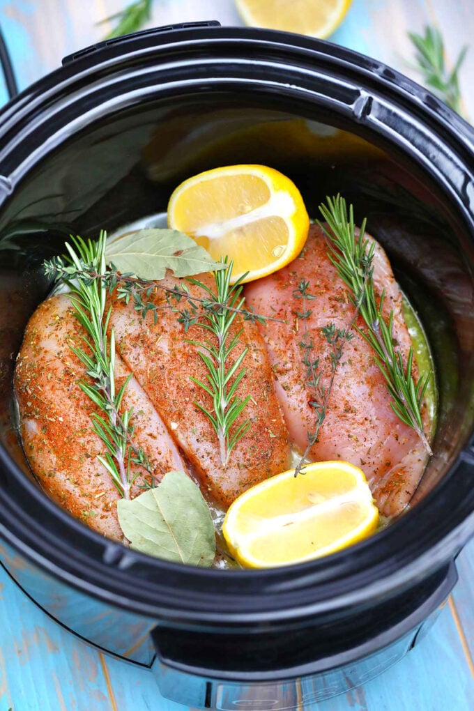 image of chicken breasts in the slow cooker with lemon and rosemary