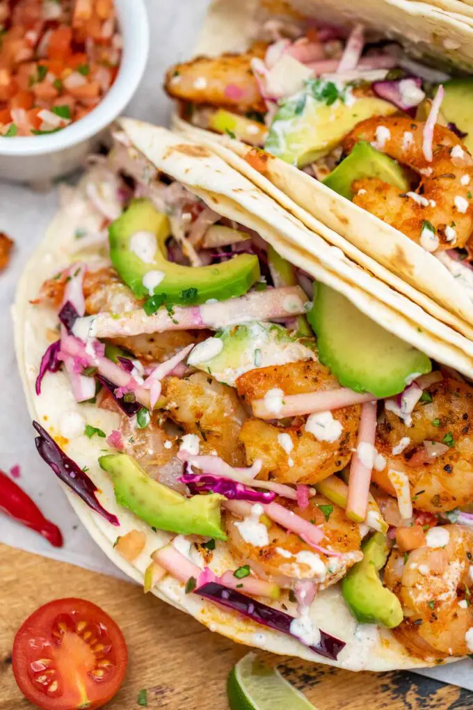 image of grilled shrimp tacos in flour tortillas with avocado