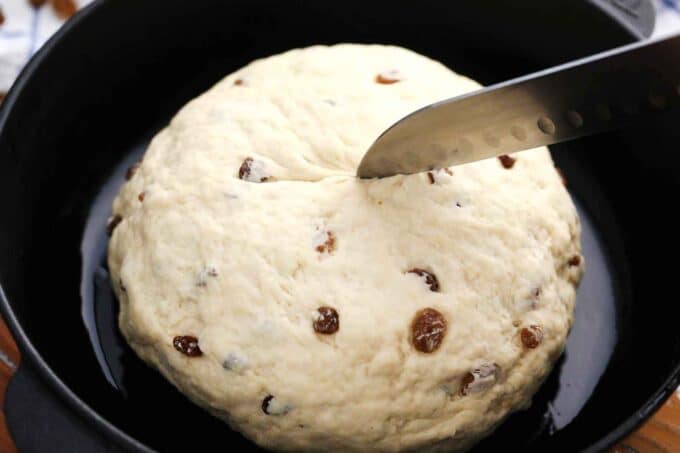 cutting a cross on top of Irish soda bread before baking it