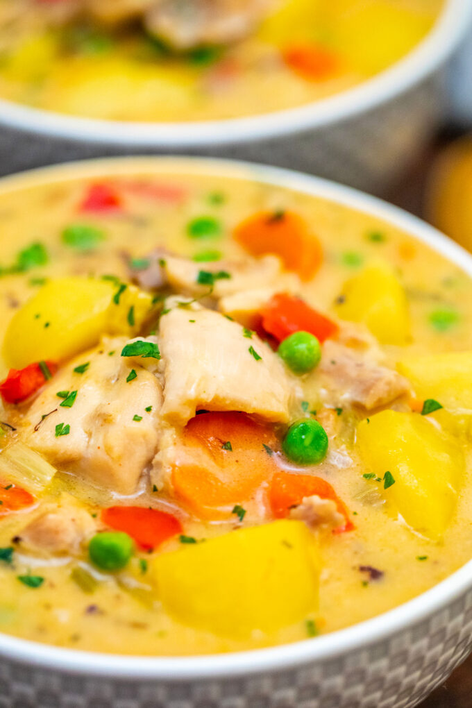 Creamy one pot chicken stew with potatoes, carrots, and peas.