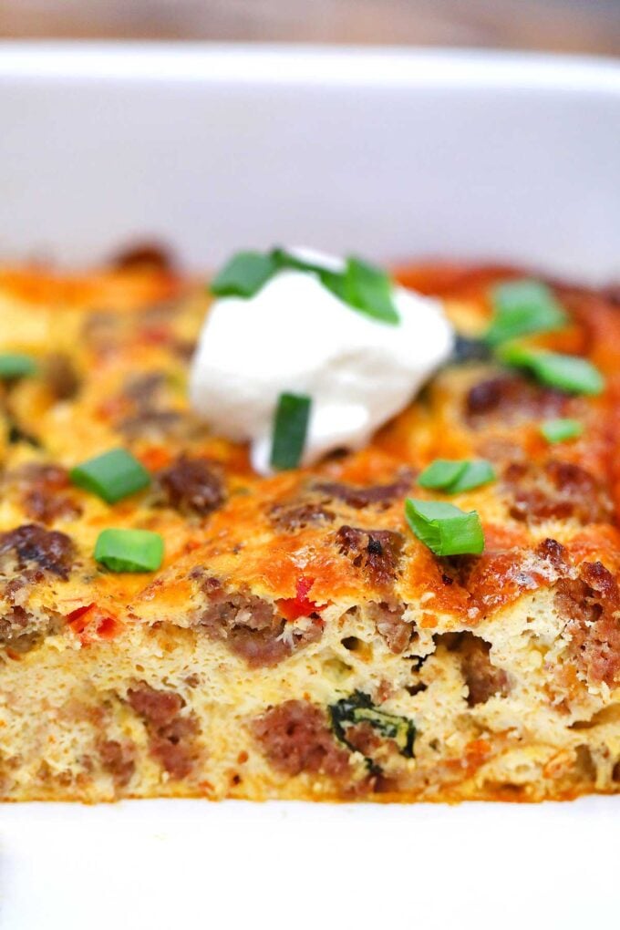 Close up of sausage breakfast casserole topped with sour cream