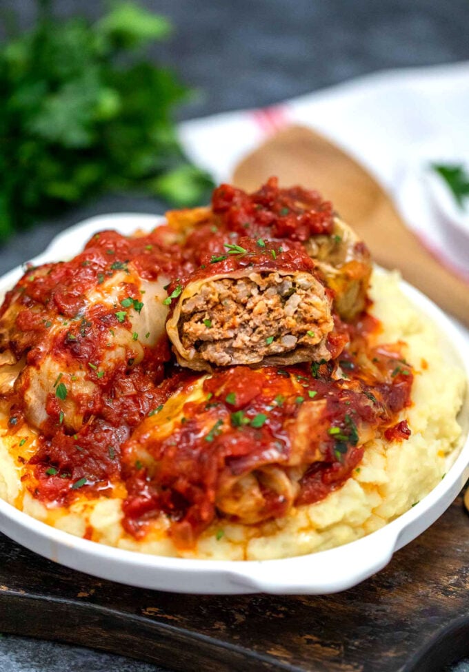 stuffed cabbage rolls on top of mashed potatoes