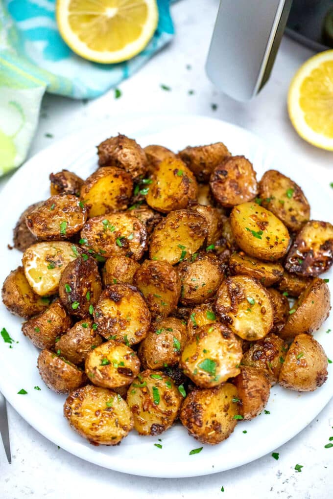 Seasoned and crispy roasted potatoes on a white plate.