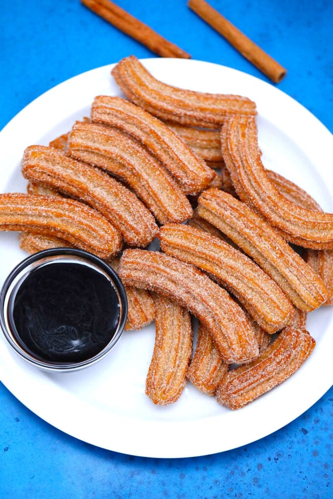 plate of fried churros and chocolate sauce