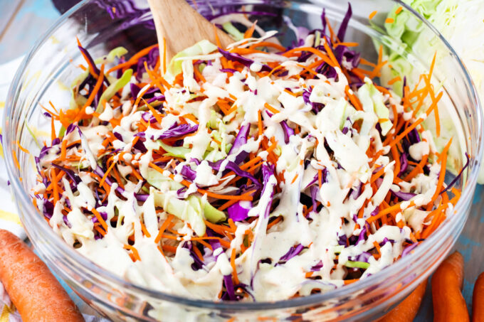 Mixing the dressing into coleslaw salad.
