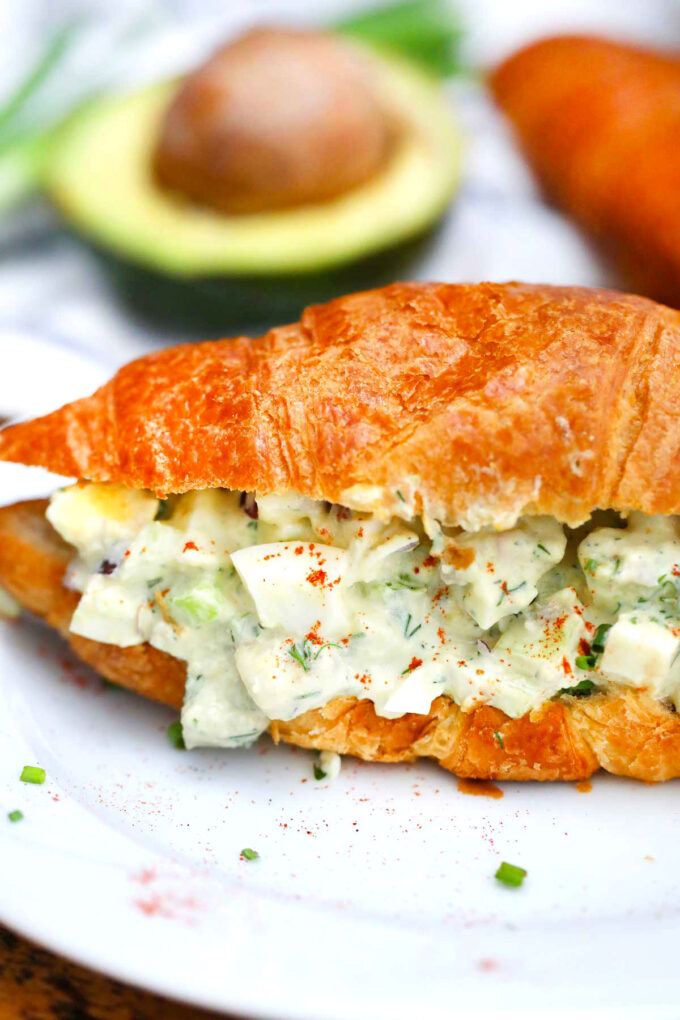 Photo of avocado egg salad on a croissant.