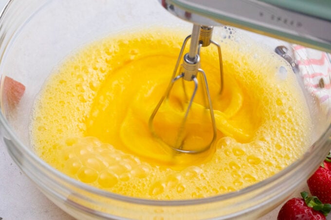 Beating eggs in a bowl.