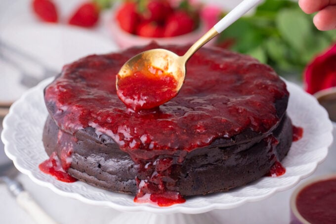 Topping chocolate flourless cake with low carb strawberry sauce.