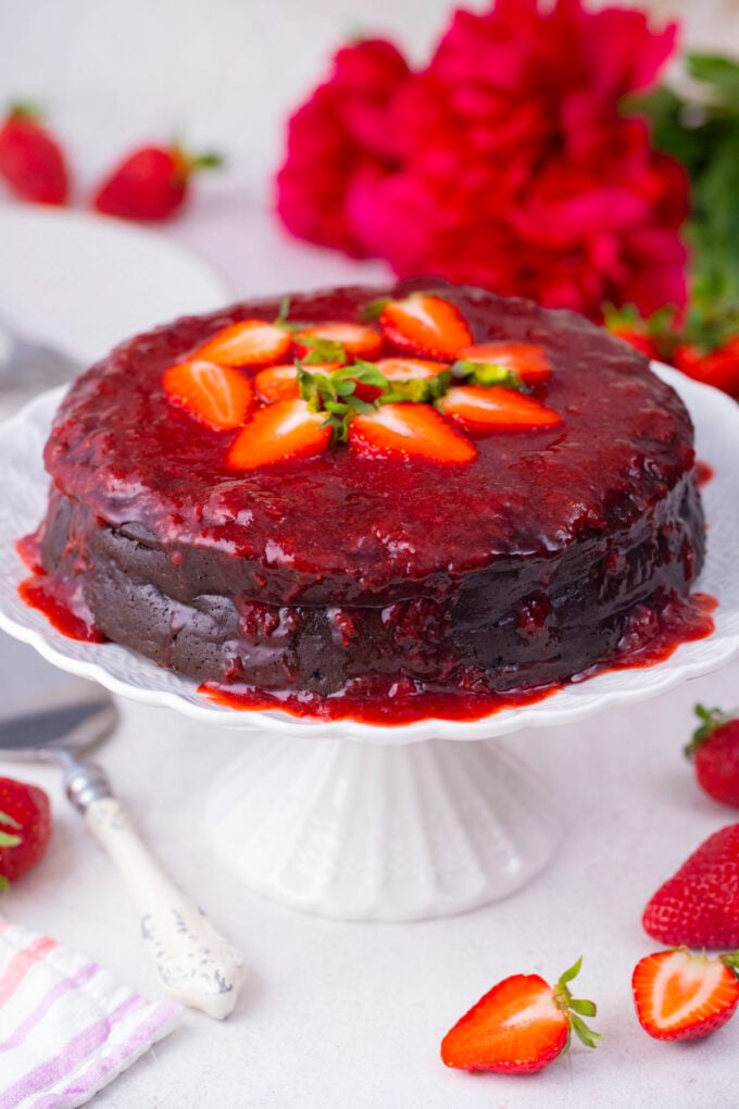 Homemade low-carb chocolate flourless cake topped with strawberry sauce.