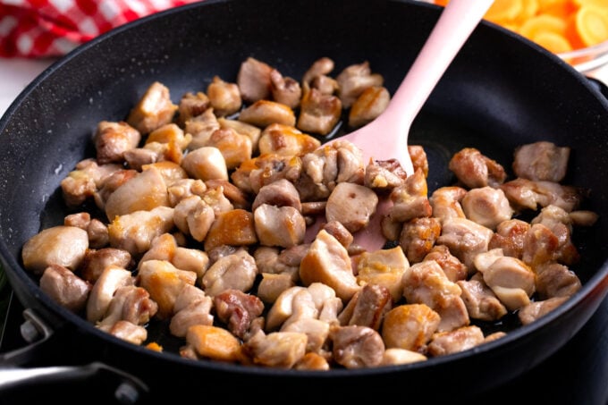 Browning chicken pieces in a pan.