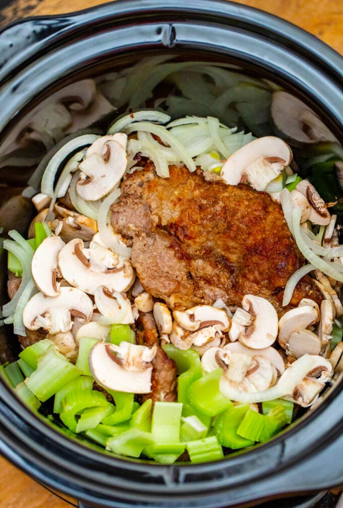 Swiss steak ingredients added to the crockpot.