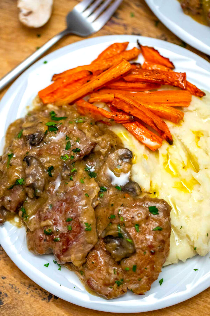 image of crockpot Swiss steak with gravy and mashed potatoes