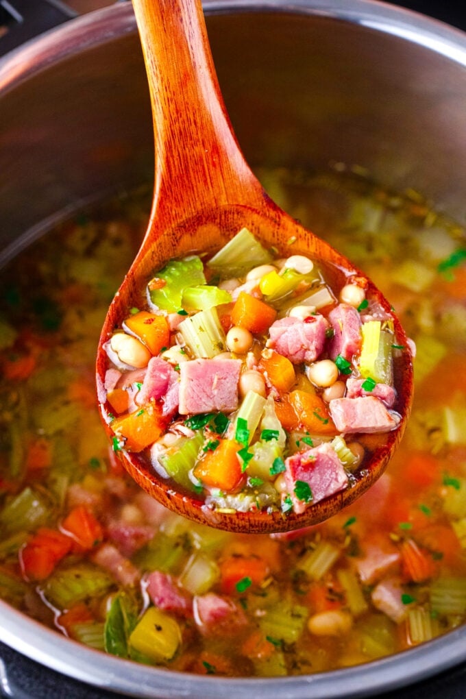 A ladle of Instant Pot ham and bean soup with veggies.