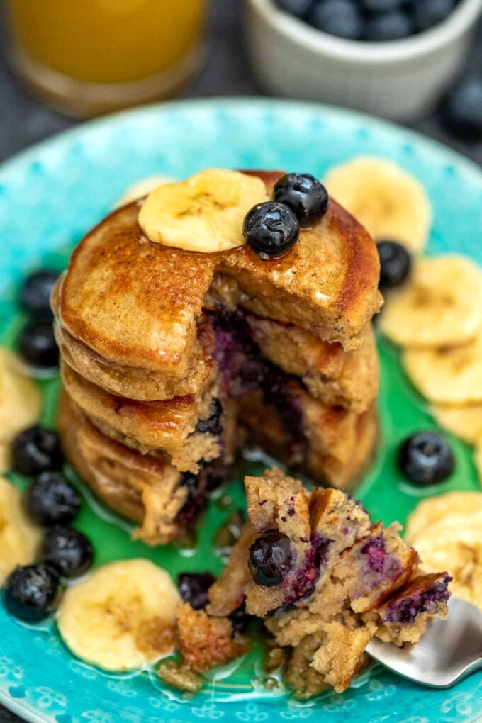 sliced blueberry oatmeal pancakes with fresh berries.