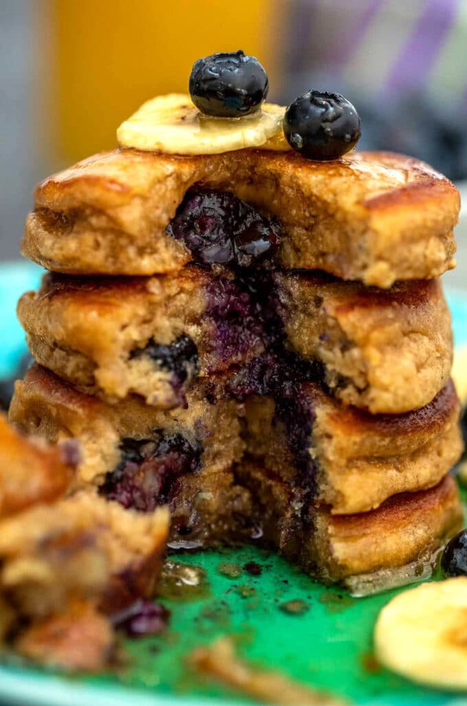 a stack of blueberry oatmeal pancakes topped with banana slices