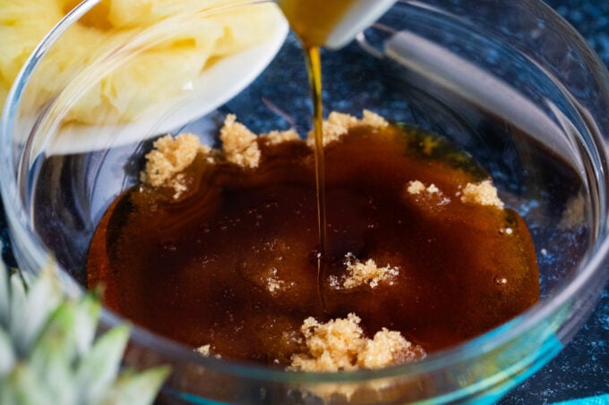 Mixing brown sugar with maple syrup in a bowl.