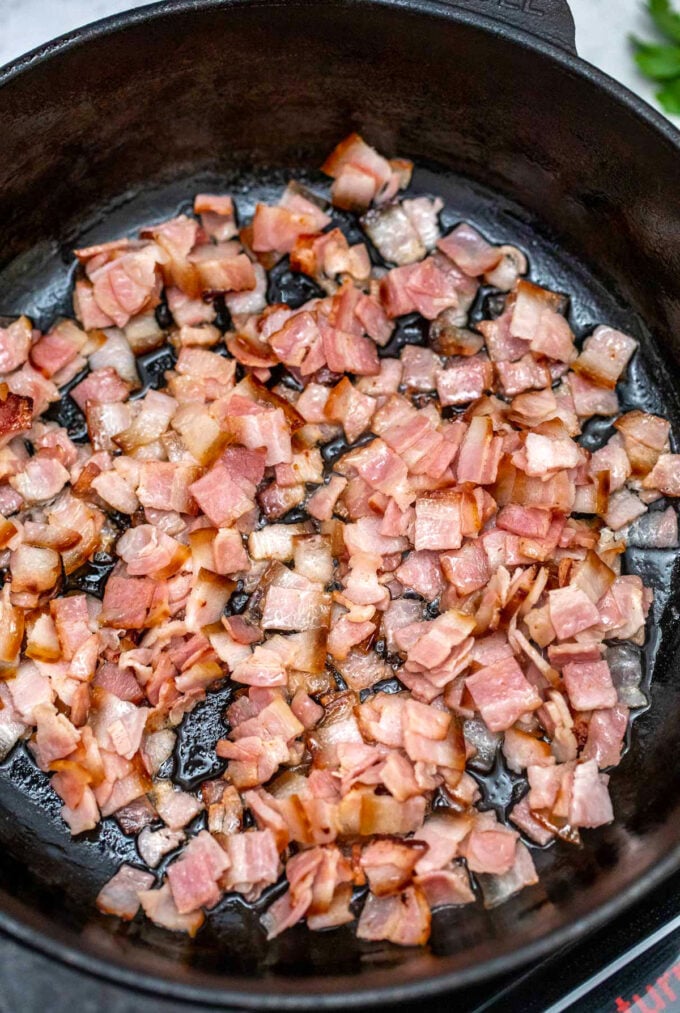 Photo of cooking bacon in a cast iron skillet.